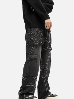 Black distressed cargo jeans with patchwork details and white stitching, styled with black sweater and sneakers