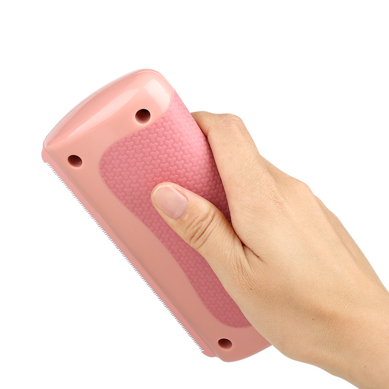 Pink handheld pet grooming brush with textured grip, ideal for cat and dog fur removal