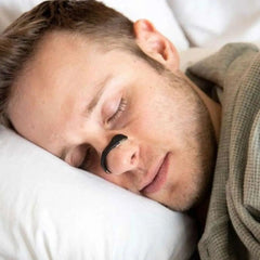 Man sleeping peacefully with nasal strip for better breathing, ideal gift for restful sleep