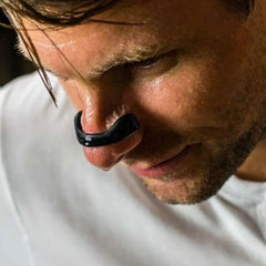 Man wearing black nasal dilator for better breathing during sleep or exercise