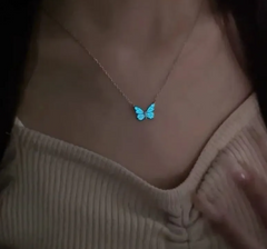 Glowing blue butterfly necklace on woman, delicate pendant for everyday wear or gift