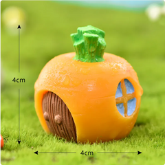 4cm orange pumpkin-shaped fairy house with green stem, brown door, blue window on grass