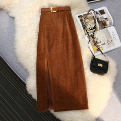 Brown corduroy midi skirt with front slit and gold buckle belt, styled with black quilted bag