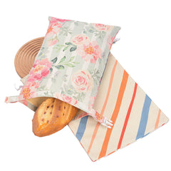 Floral and striped reusable bread bags with fresh loaf, eco-friendly kitchen storage