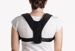 Black posture corrector brace worn on back for improved alignment and comfort