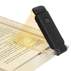 Black LED book light with clip-on design illuminating open book pages for reading