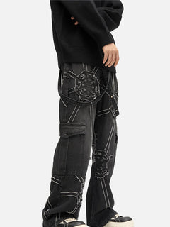 Black distressed cargo jeans with patchwork design, ripped details, and white stitching for edgy streetwear style