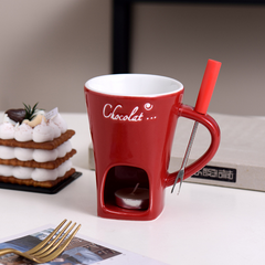 Red chocolate fondue mug with candle base and fondue fork, perfect for cozy desserts