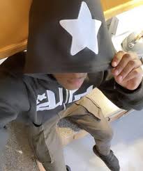 Child wearing black hoodie with white star, casual kids fashion
