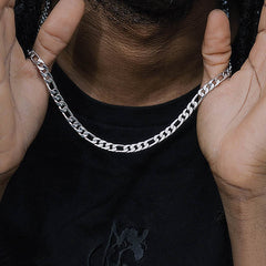 Silver figaro chain necklace worn by man in black tee, stylish men's jewelry gift