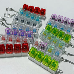 Colorful mechanical keyboard keycap keychains in red, green, purple, and clear designs