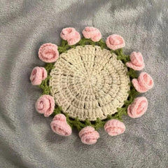 Handmade crochet coaster with pink roses and green leaves, perfect for home decor or gifts