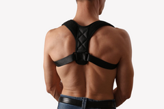 Black posture corrector brace worn on man's back for improved alignment and support