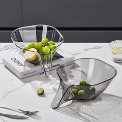 Modern clear fruit bowls with grapes and limes on marble countertop, stylish kitchen decor