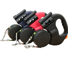 Retractable dog leashes in black, red, and blue with ergonomic handles and metal clips for safe walks