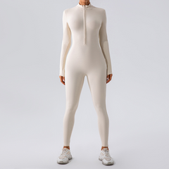 Cream long sleeve zip-front bodysuit with matching leggings and white sneakers, perfect for fitness or loungewear