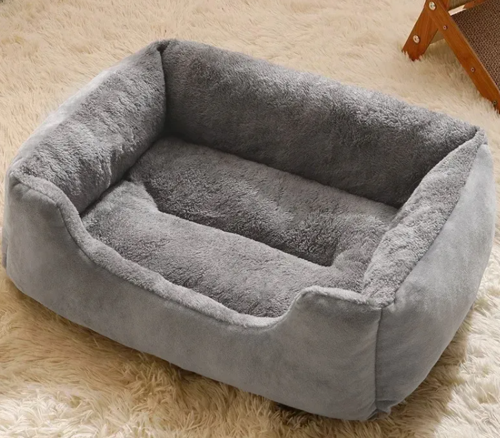 Soft gray plush pet bed for dogs or cats, cozy and comfortable on fluffy rug