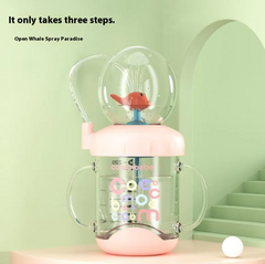 Pink baby sippy cup with whale spray toy, colorful letters, dual handles, ideal for toddler drinks and play