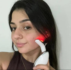 Woman using red light therapy device on face for skincare and facial rejuvenation