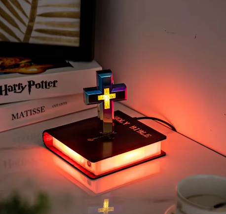 Glowing cross night light on Holy Bible, warm ambient lighting for bedroom decor
