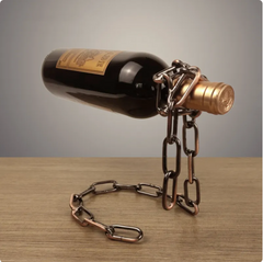 Metal chain wine bottle holder displaying red wine on wooden table, unique gift idea