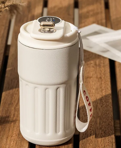 White smart travel mug with digital temp display, coffee strap, on wooden table
