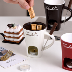 Chocolate fondue mug with melting chocolate cubes, candle heater, and dipping fork for cozy dessert treats