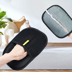 Black pet grooming glove with mesh design, gently brushing cat fur in cozy home setting
