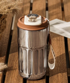 Stainless steel smart water bottle with temperature display and carry strap on wooden table