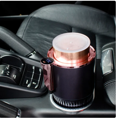 Rose gold car coffee maker with digital temp display, brewing in vehicle cup holder