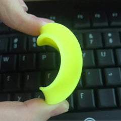 Bright yellow crescent moon stress ball held over keyboard, fun desk toy for stress relief