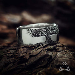 Silver tree of life ring with detailed bark texture, nature-inspired men's wedding band on rustic wood