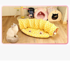 Yellow polka dot cat tunnel with cozy cat bed and playful feline on wooden floor