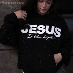 Black hoodie with 'Jesus Is the Light' text, sparkly design, no back logo