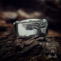 Silver ring with engraved tree of life design, rustic bark background, meaningful gift for family